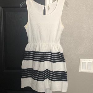 White dress with black stripe on bottom half .